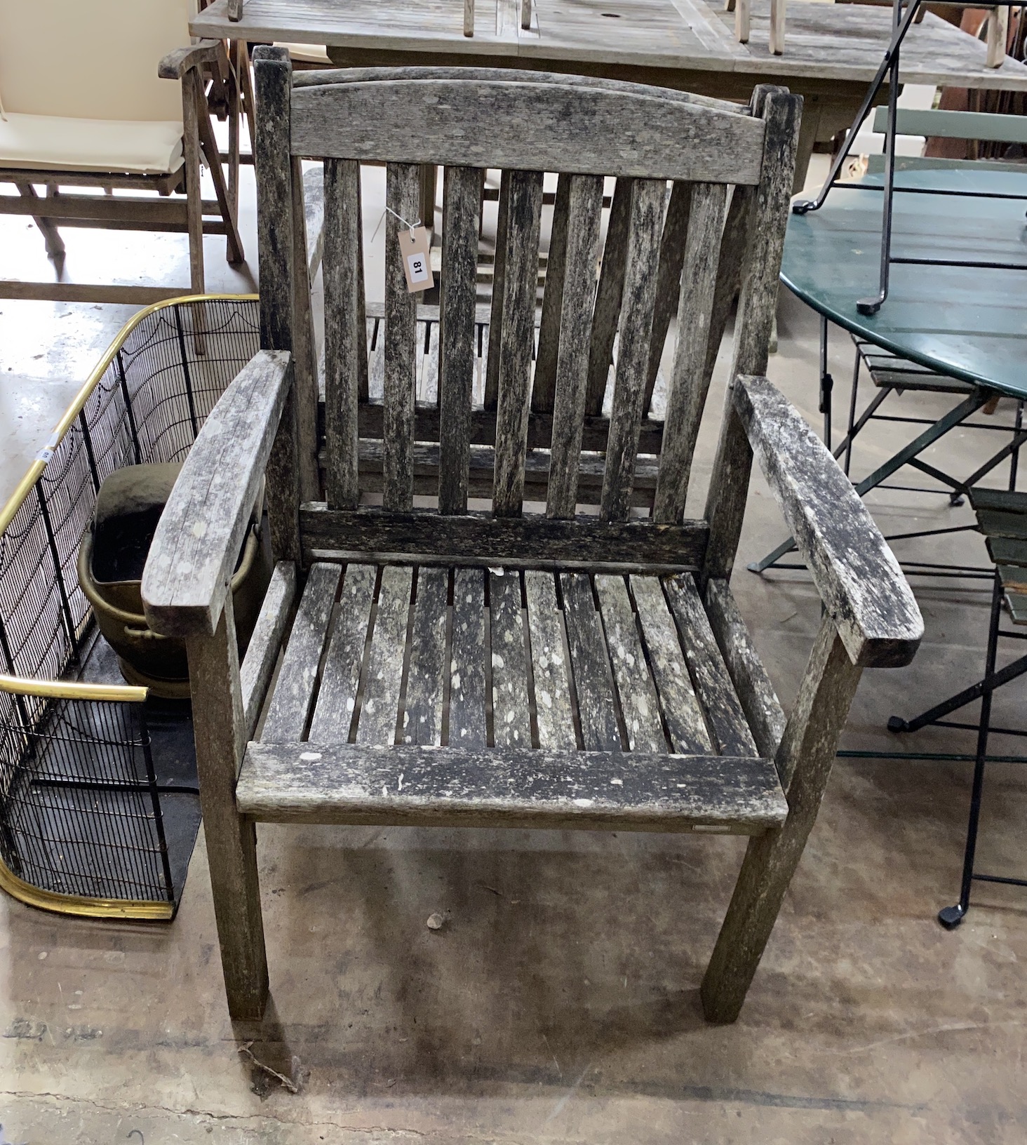 A pair of weathered teak garden elbow chairs, width 68cm, depth 52cm, height 95cm